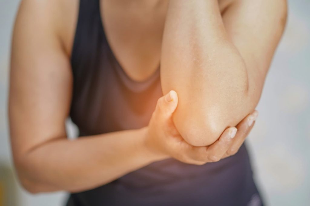 A female holding her elbow due to pain