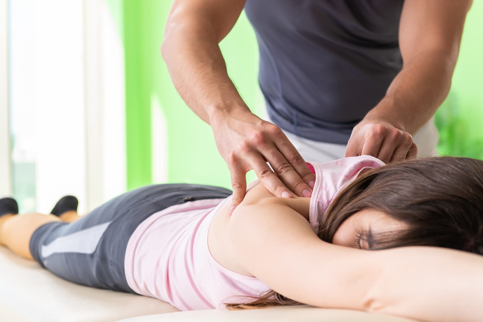 Young doctor chiropractor massaging patient